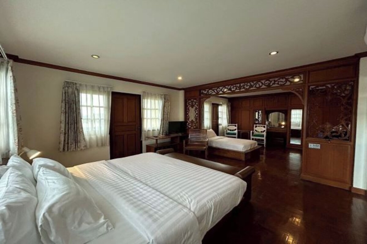 Une chambre d’hôtel avec un grand lit, un bureau, une chaise et une armoire.