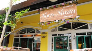 Un edifici amb un rètol que diu “Norn-Nanta House” i una porta verda.