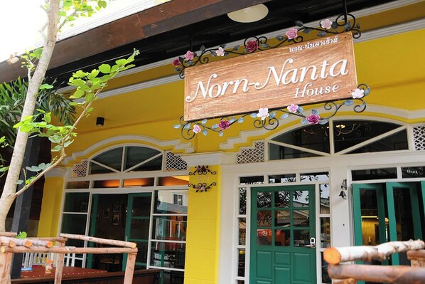 Un edificio con un letrero que dice "Norn-Nanta House" y una puerta verde.