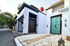 A modern building with a white exterior, a green door with a number '6', and a satellite dish on the roof. - Bm Pool Villa Pattaya (Sattahip)