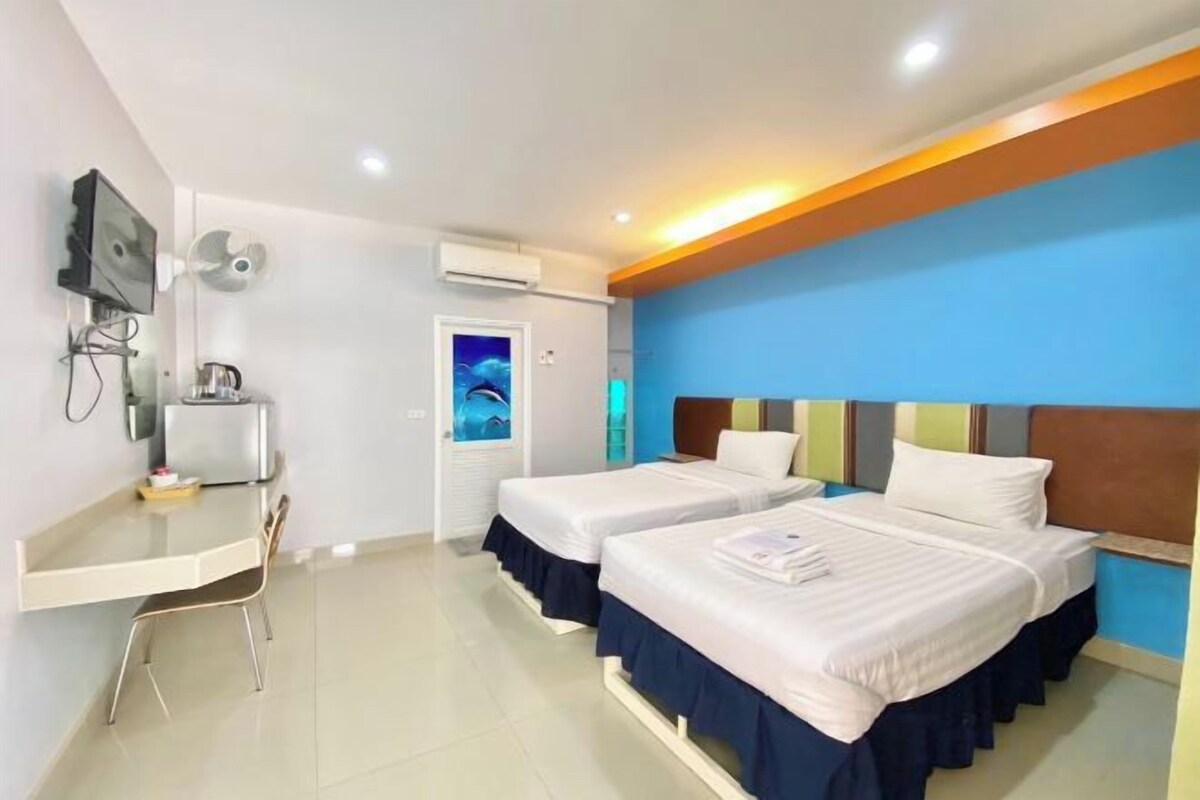 Une chambre d’hôtel avec deux lits, un bureau, une télévision et un appareil de climatisation.