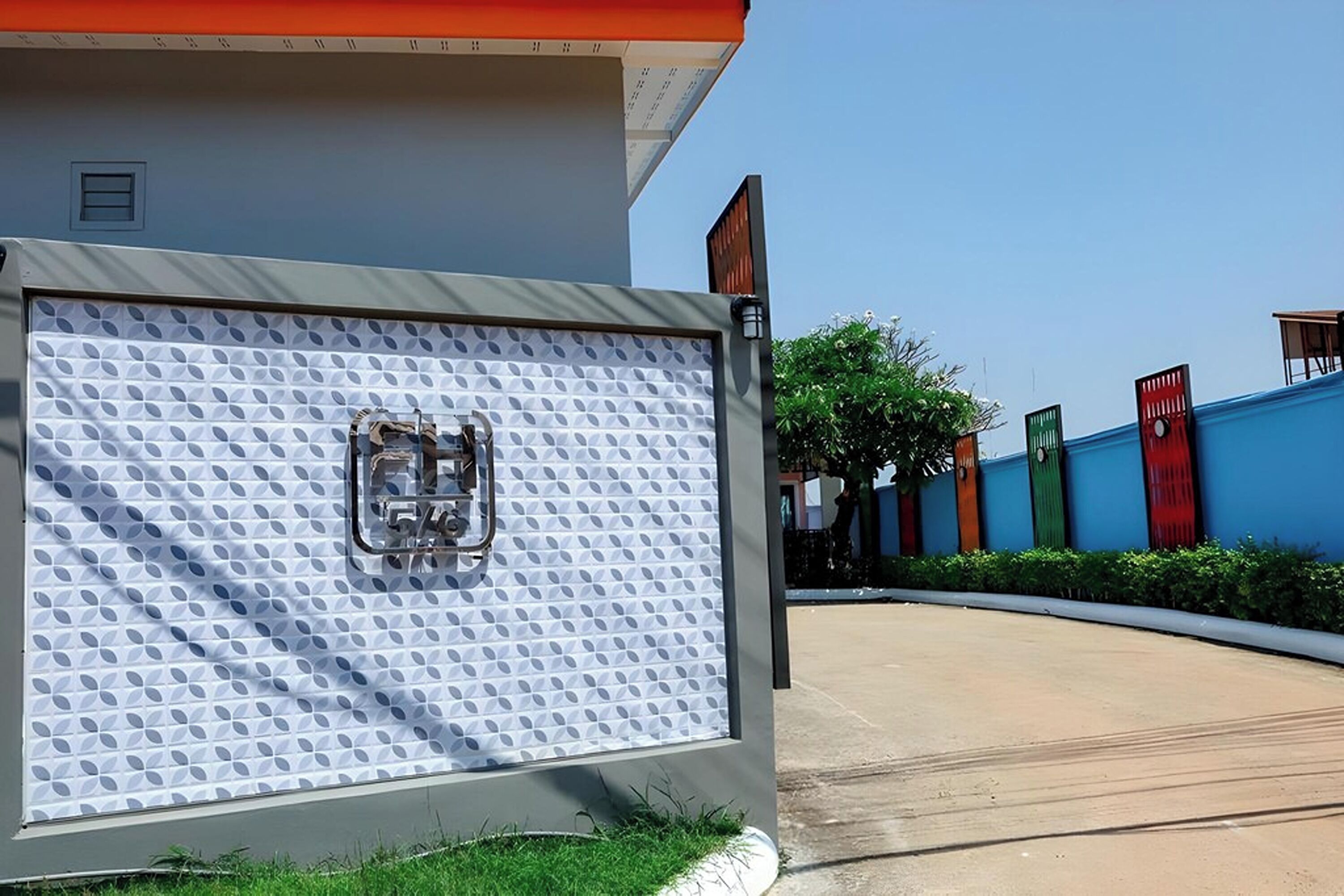 A building with a textured facade, a visible door, and a clear sky.