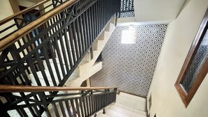 A staircase with a black metal railing and patterned floor tiles. - Hotel Ramayana Garut (Garut)