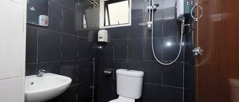 Un baño con lavamanos, inodoro y ducha blancos.
