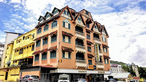 Ein mehrstöckiges Hotel mit traditioneller Architektur, mit Balkonen und einer deutlichen Hotelschild.