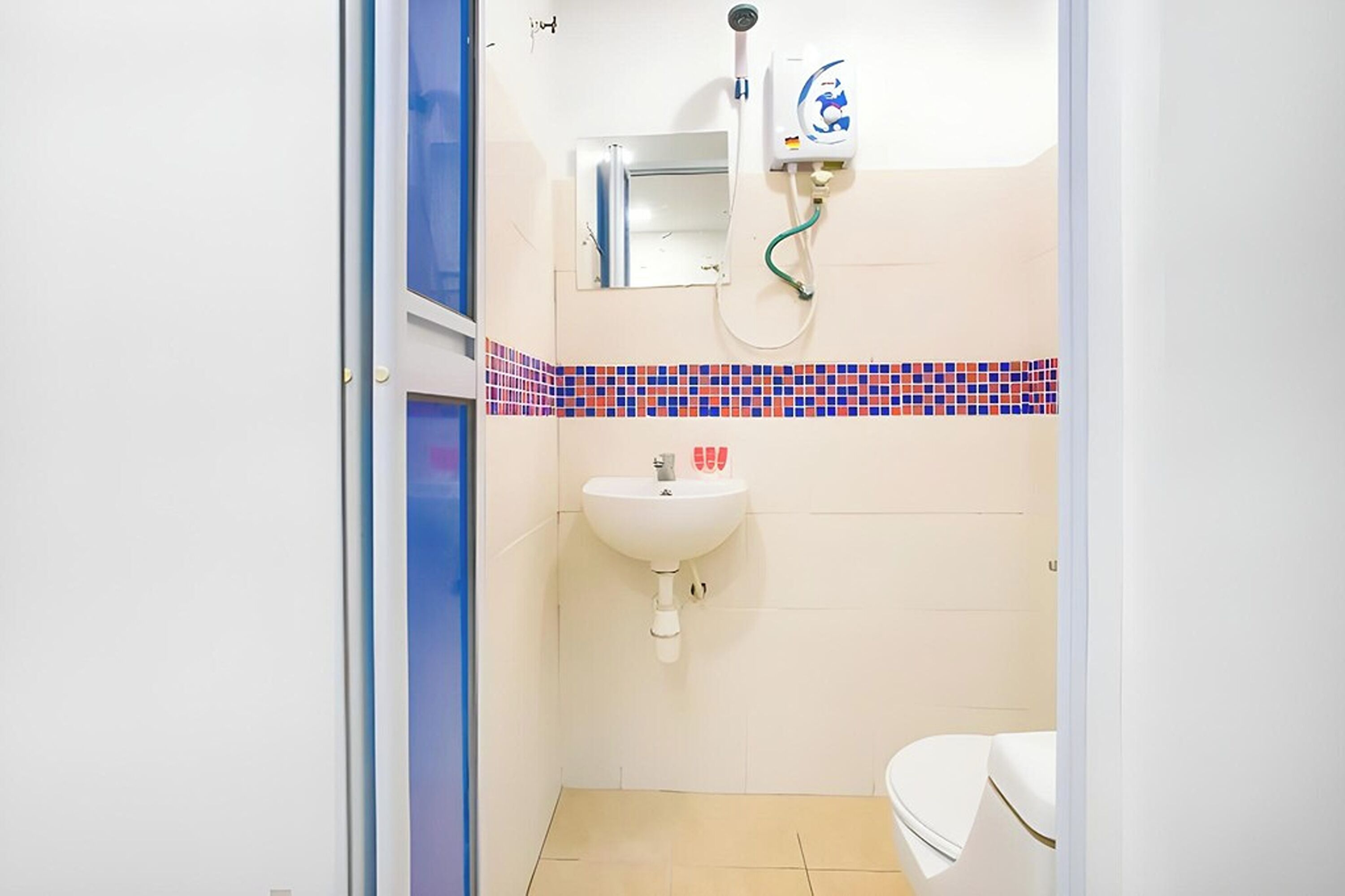 A small bathroom with a white sink, a mirror, and a shower.