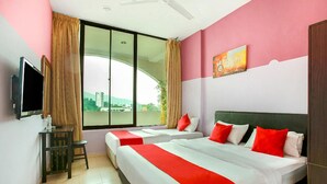 A hotel room with two beds, a TV, a small table, and a window with a view of buildings. - Feringghi Stay Iinn (George Town)