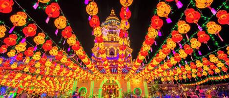 A traditional building with a multi-tiered roof, surrounded by a festive display of lanterns and lights.