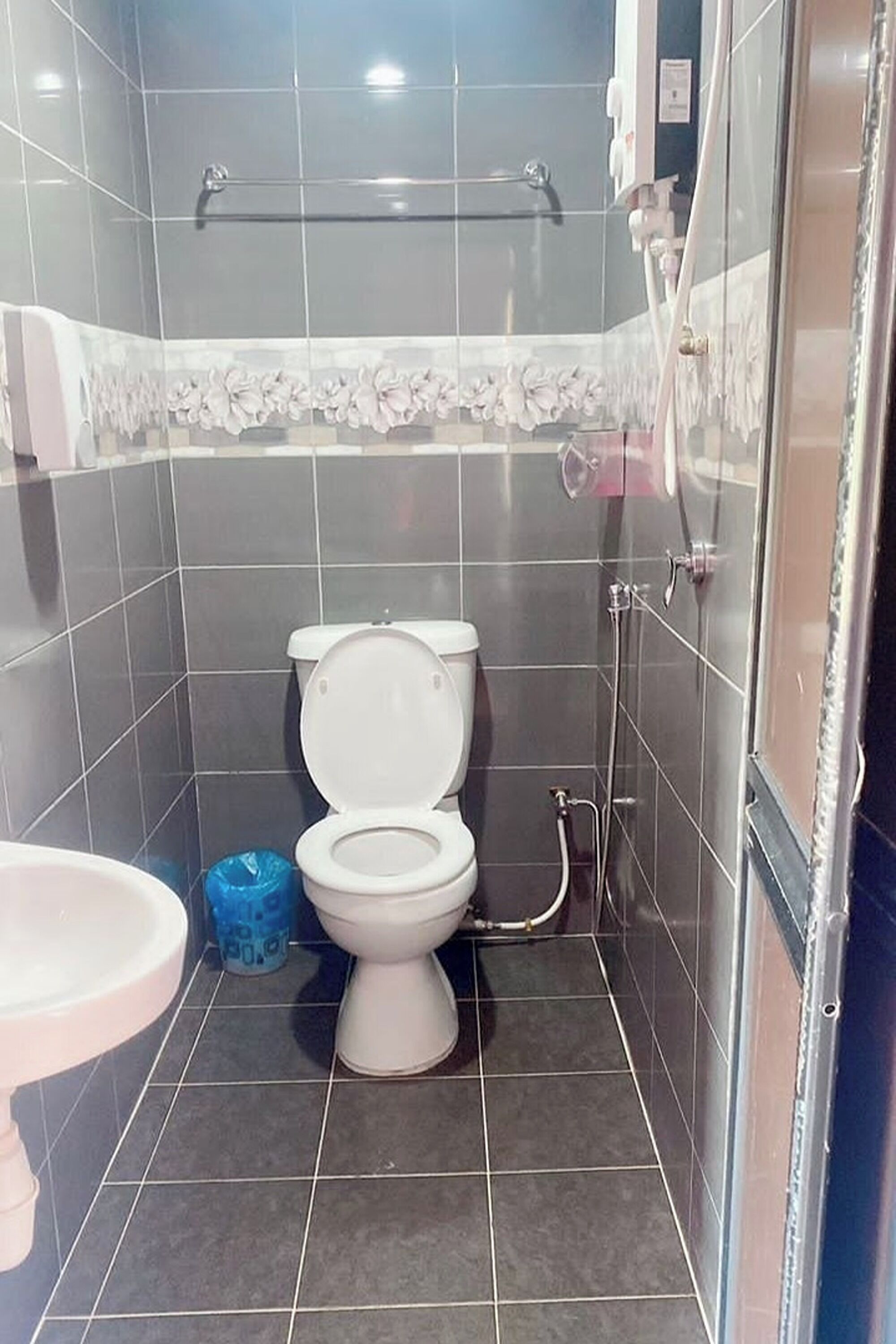 Un baño con inodoro, lavamanos y zona de ducha.