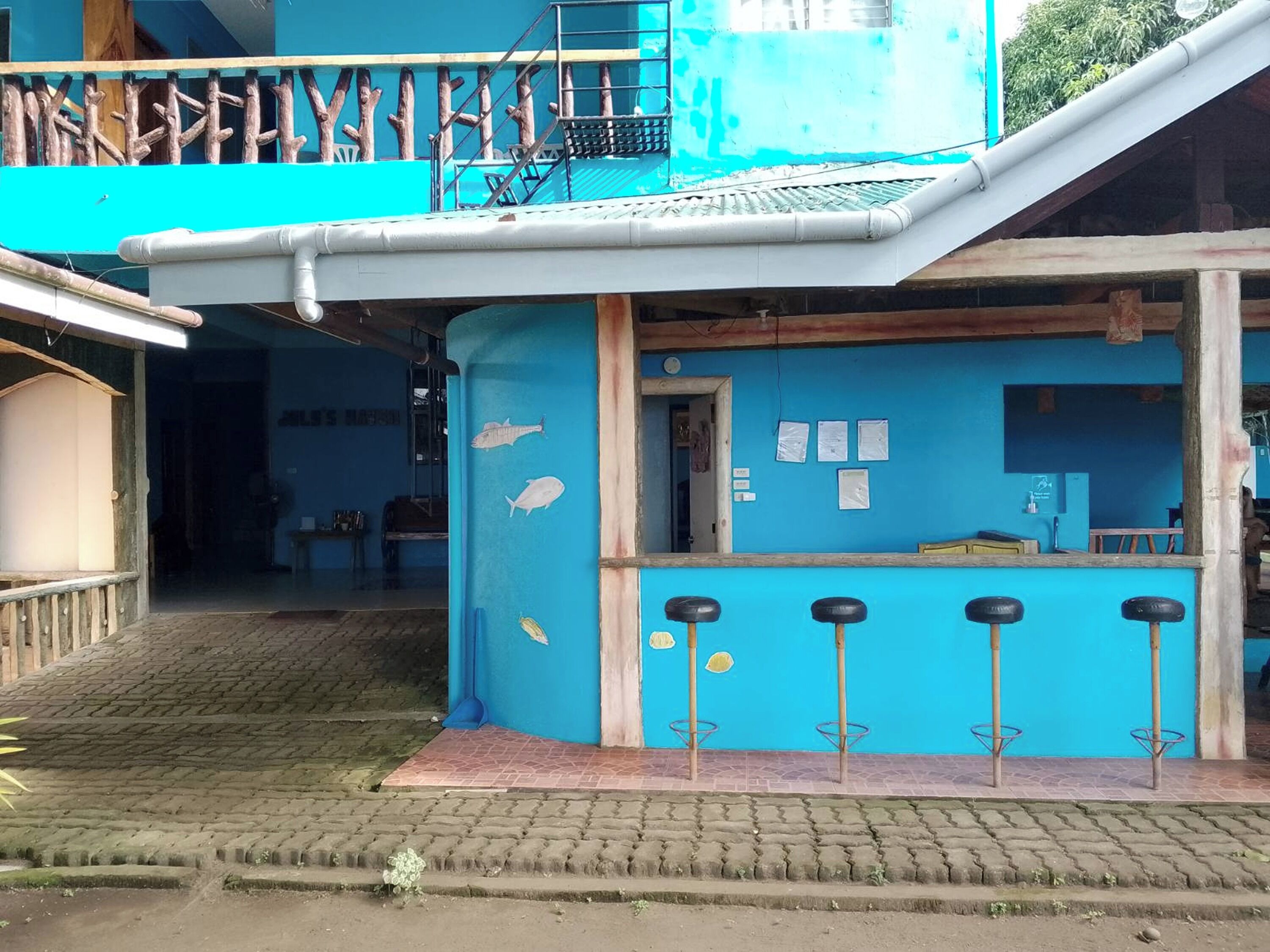 Een blauw gebouw met een bar, inclusief krukken en een bar.