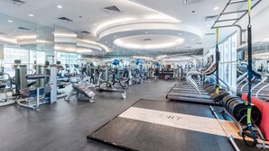 A modern gym with various exercise equipment, including treadmills, weight machines, and free weights.