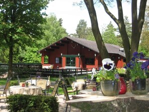 Guests can enjoy the tranquil atmosphere in this outdoor seating area surrounded by trees and lush greenery.