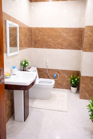 Habitación estándar doble | Baño | Ducha, artículos de higiene personal gratuitos, zapatillas y jabón