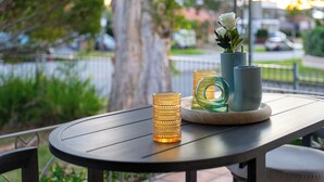 Une table ronde ornée de deux vases et de bougies, placée sur une terrasse.