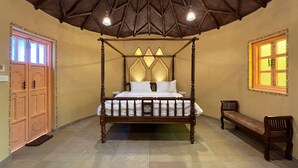 A four-poster bed with a canopy, a bench, and a window with patterned glass. - Monteria Village  (Khalapur)