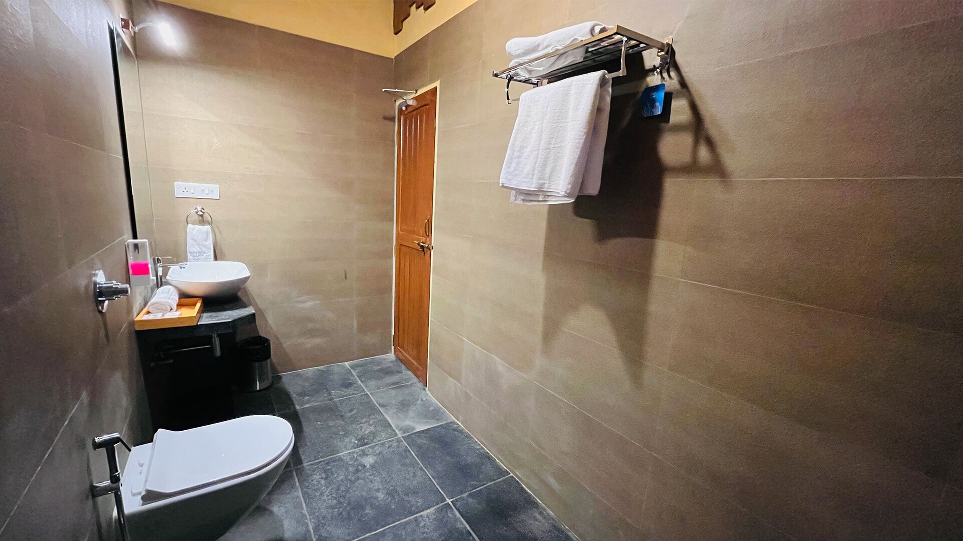 Pieni kylpyhuone, jossa on wc, pesuallas ja suihku.
