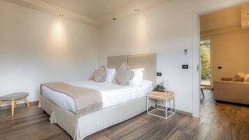 A modern bedroom with a large bed, bedside tables, and a view of a balcony.