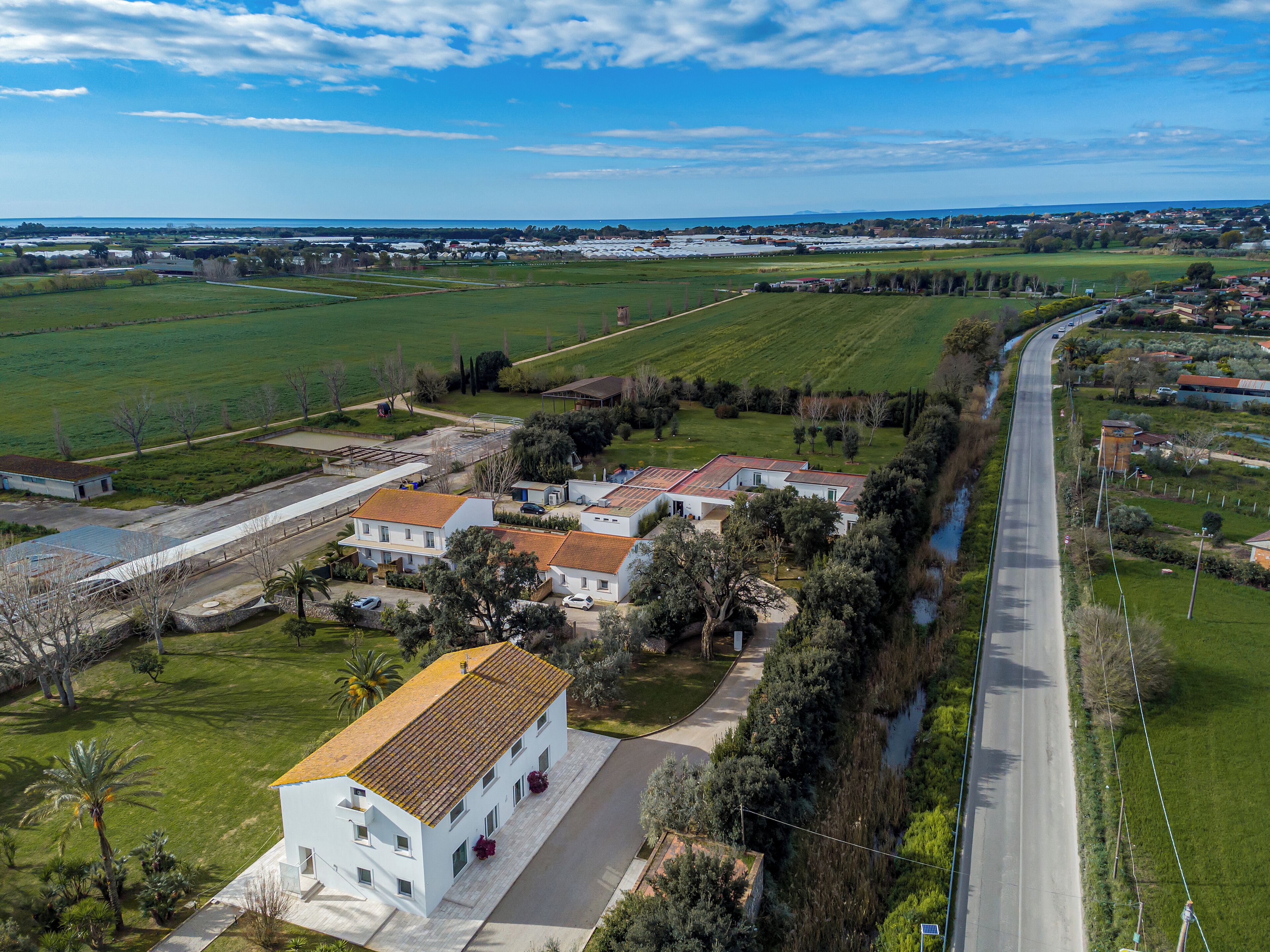 An aerial view of a residential area with houses, roads, and green fields.