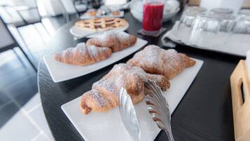 Una mesa de desayuno con pasteles y un vaso de jugo.