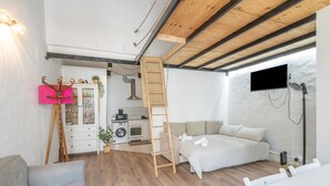Een slaapkamer met een bed, bureau, stoel, kast, televisie en een badkamer met douche.