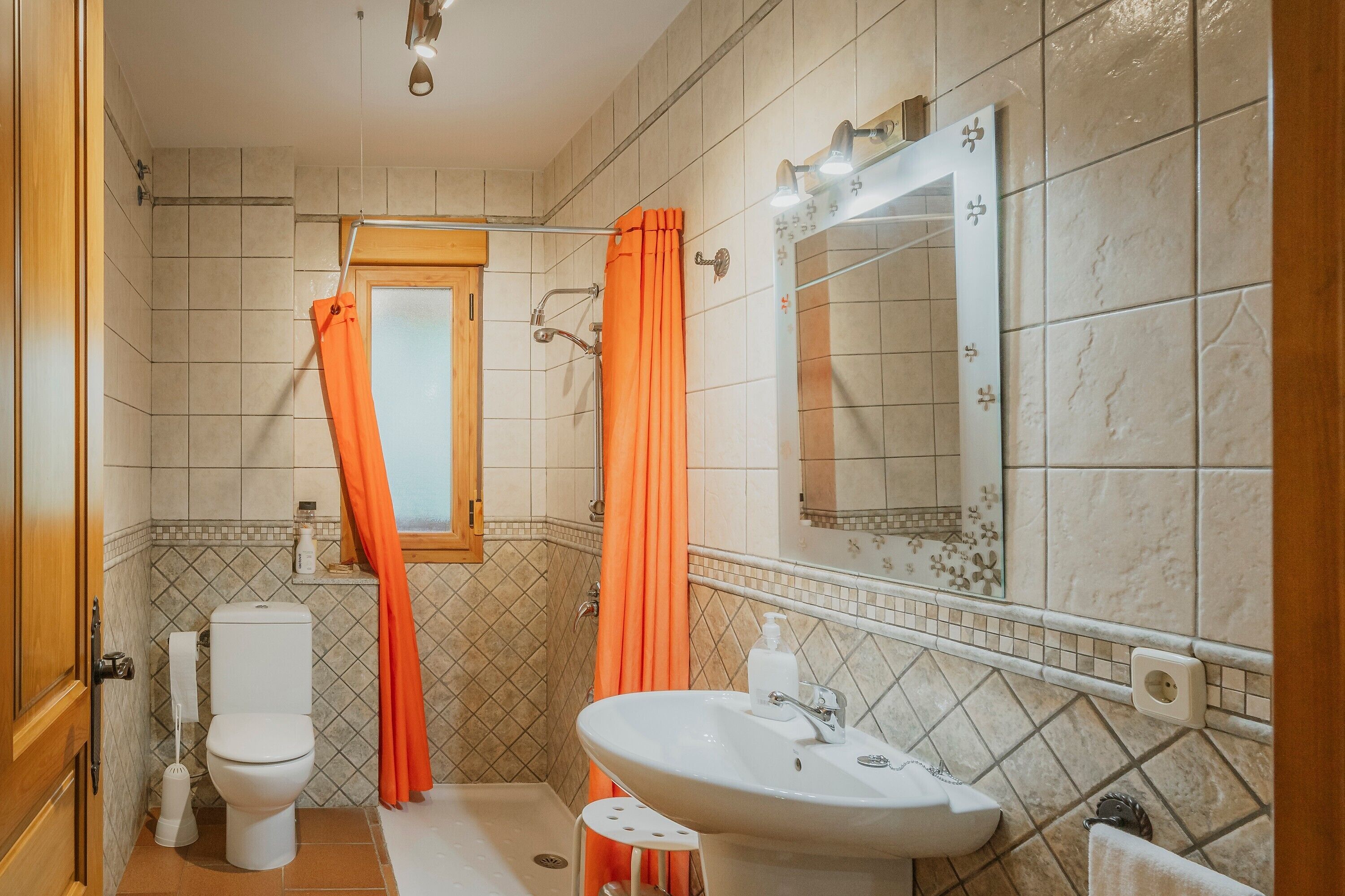 Ein Badezimmer mit Toilette, Waschbecken, Dusche und Spiegel.