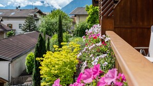 A balcony with a wooden railing overlooking a garden with various plants and flowers. - Apartment 'Christine 1' with Mountain View, Shared Pool and Wi-Fi (Riffian)