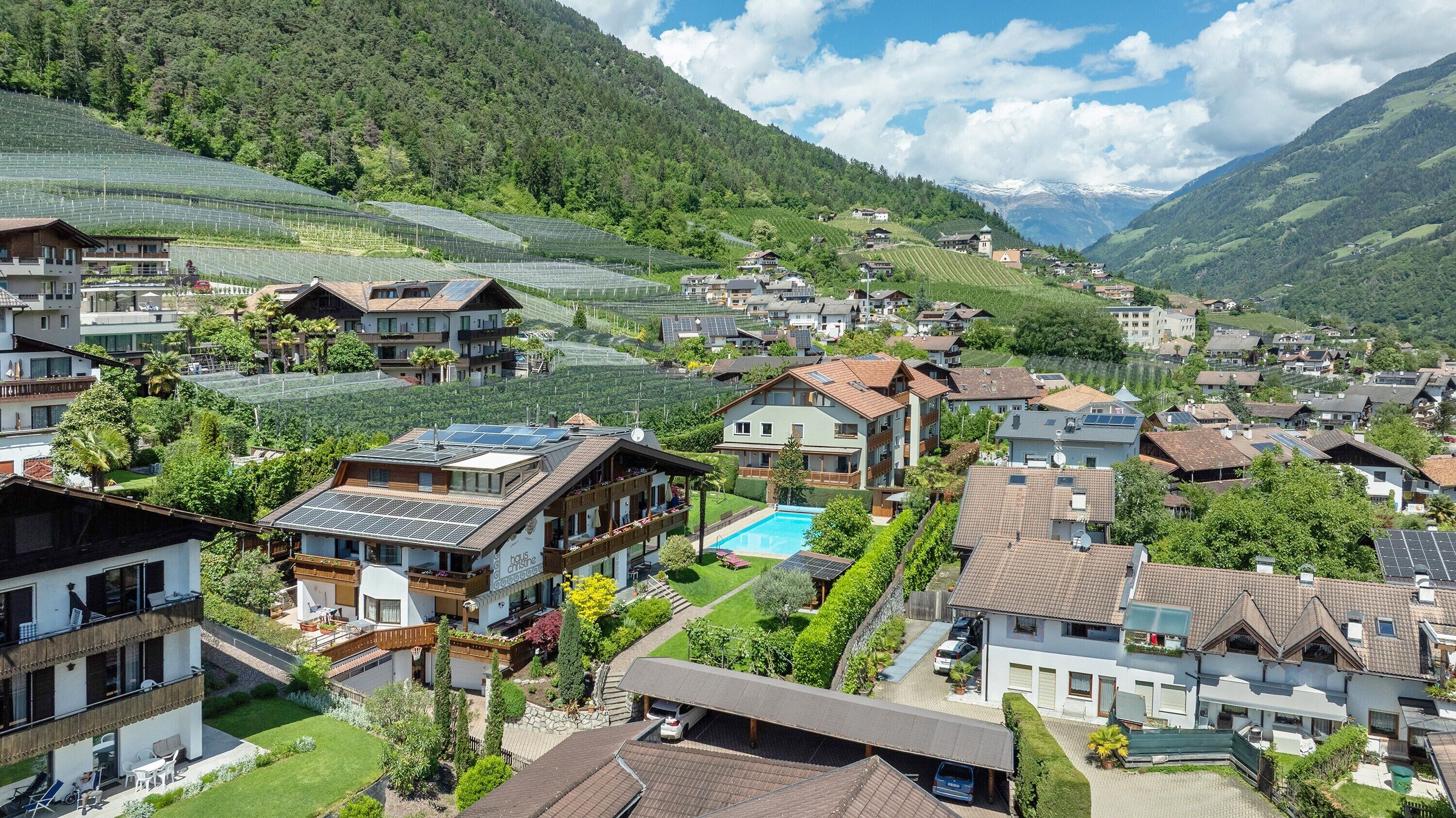 A residential area with houses, a swimming pool, and solar panels.