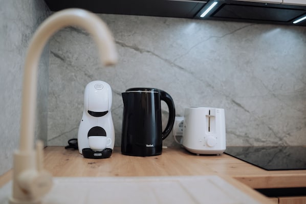 A kitchen with a coffee maker, a black mug, and a toaster on the counter.