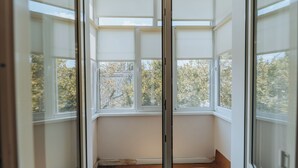 Ein Zimmer mit einem großen Erkerfenster, weißen Wänden und Holzboden.