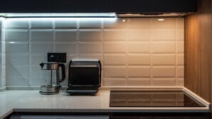 Una cocina moderna equipada con tostadora, cafetera y lavavajillas.