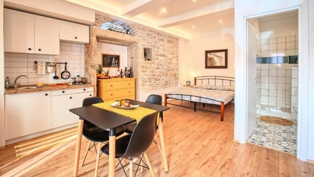 A compact living space with a kitchen, dining area, and a bedroom. - Apartment Irma: Studio apartman (Pula)