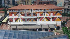 A multi-story building with a patterned facade, a ground-level commercial space, and a visible entrance. - Bazaar Hotel  (Tirana)