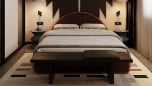 A modern hotel room with a large bed, two bedside tables, and a unique maple leaf wall design. - Bazaar Hotel  (Tirana)