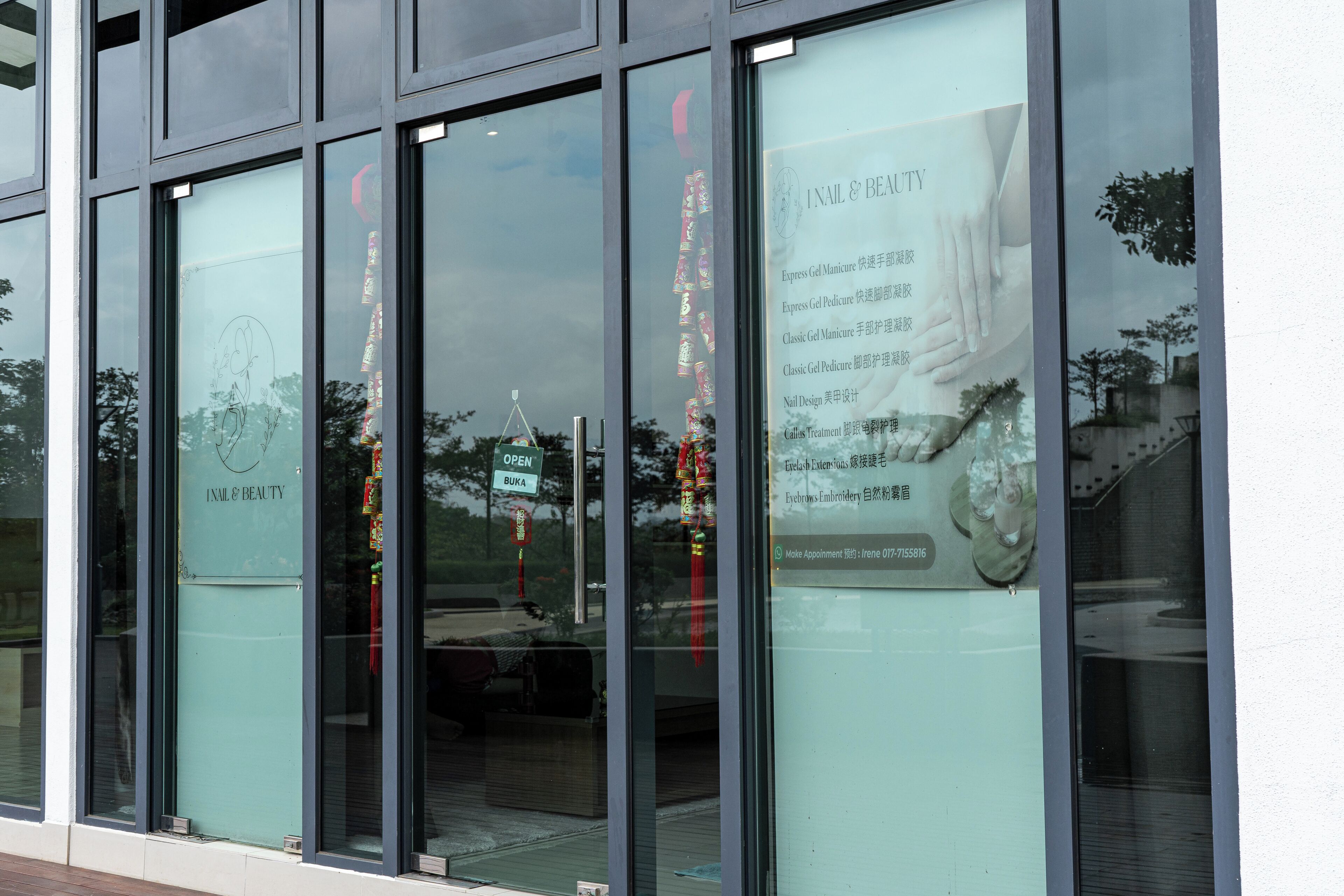 A storefront with large glass windows displaying various services and a sign indicating the business is open.