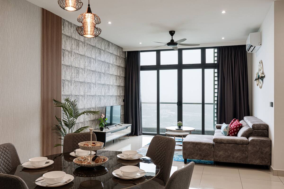 Un salon moderne avec un coin repas, de grandes fenêtres et une vue sur la ville.