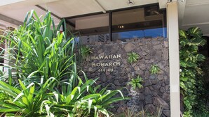 A stone wall with a sign reading "HAWAIIAN MONARCH 444 NIU". - Canoe Palms Waikiki Pool, Hot Tub, Gym, WiFi, AC (Honolulu)
