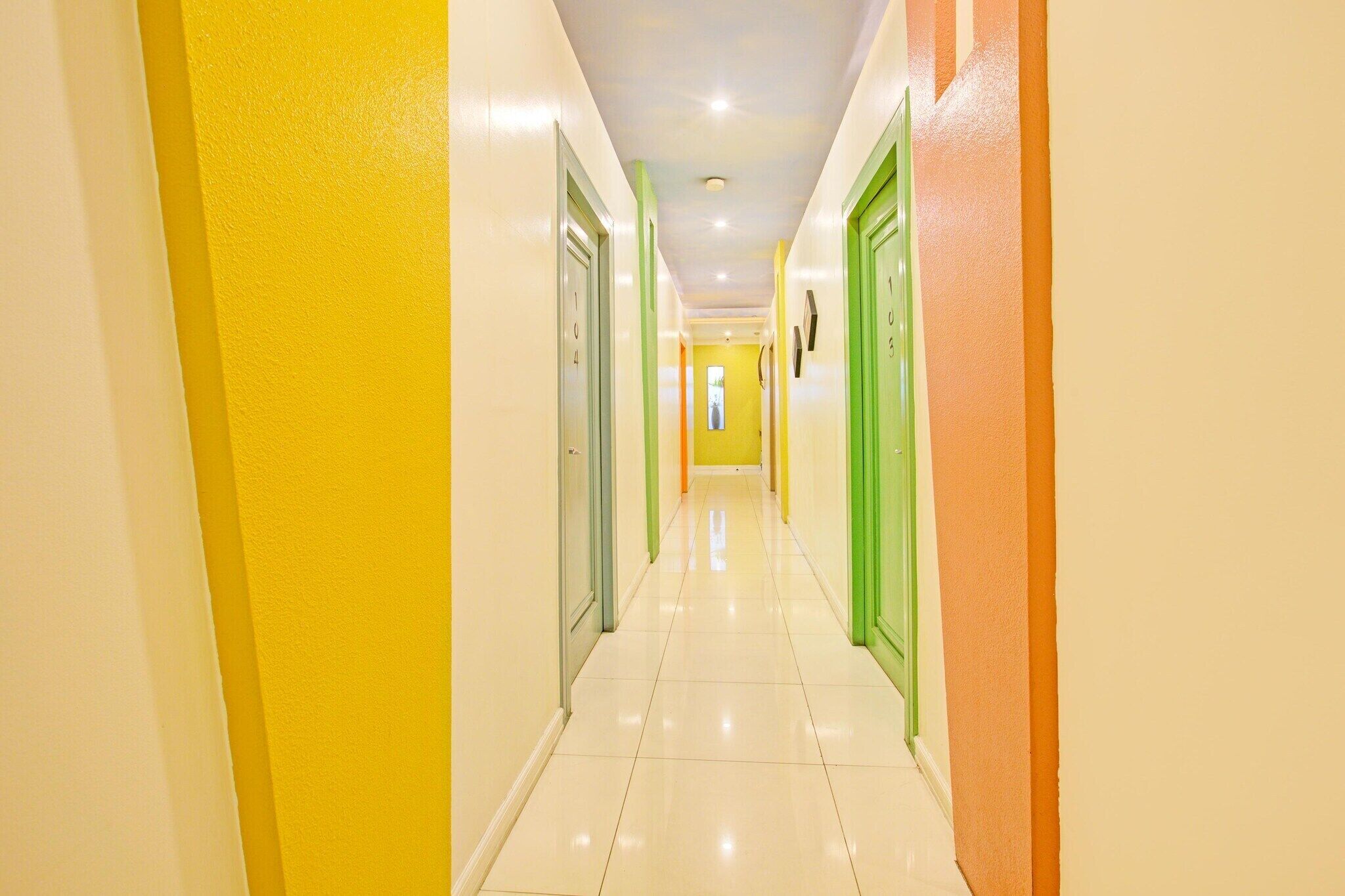 A brightly colored hallway with doors numbered 1 to 5, leading to rooms.