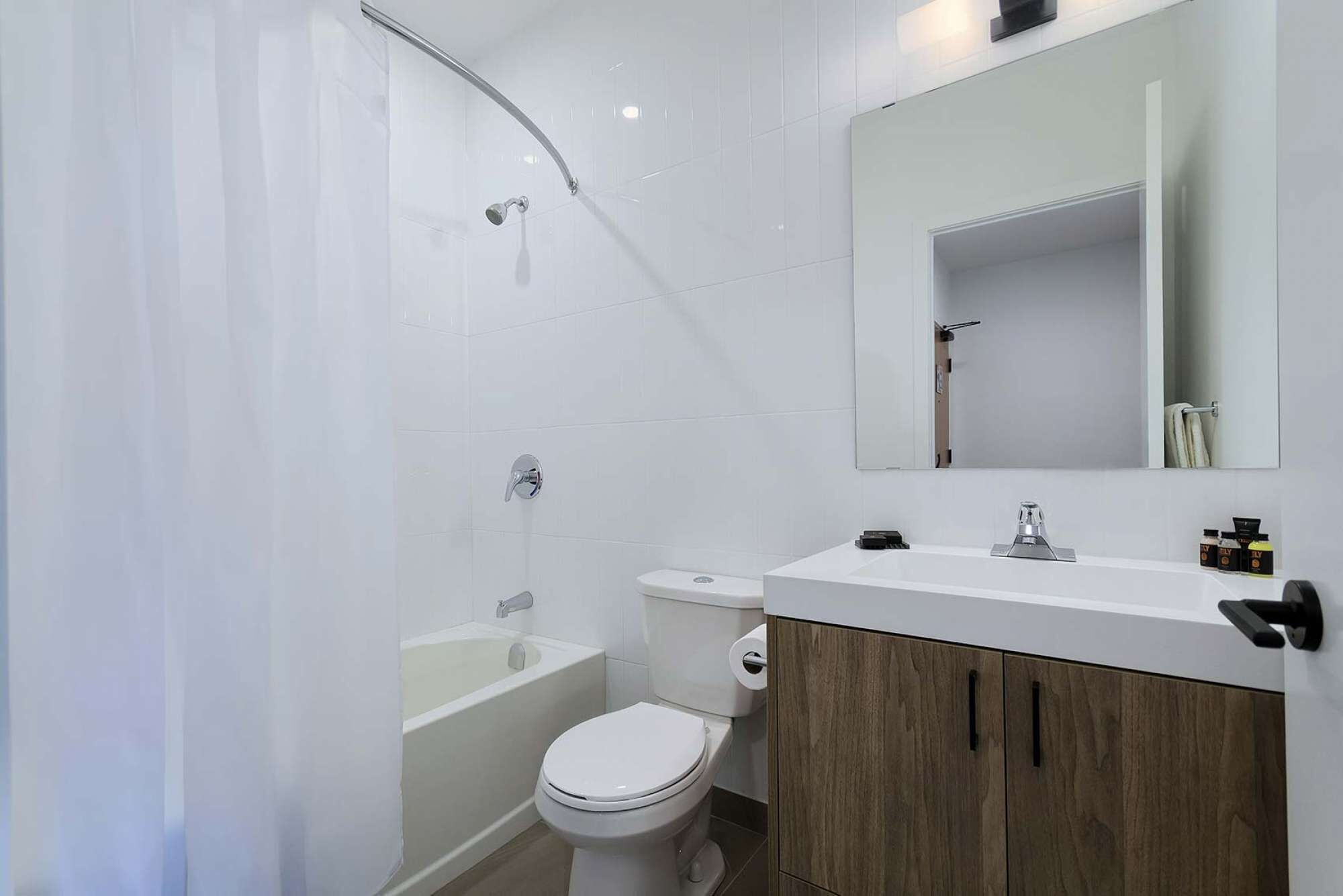 A modern bathroom with a shower, toilet, and vanity.
