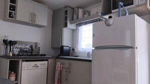 A compact kitchen with a dishwasher, a microwave, and a refrigerator. - Mobile home with private parking (Fréjus)