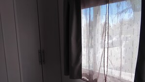 A bedroom with a bed, a wardrobe, and a window with curtains. - Mobile home with private parking (Fréjus)
