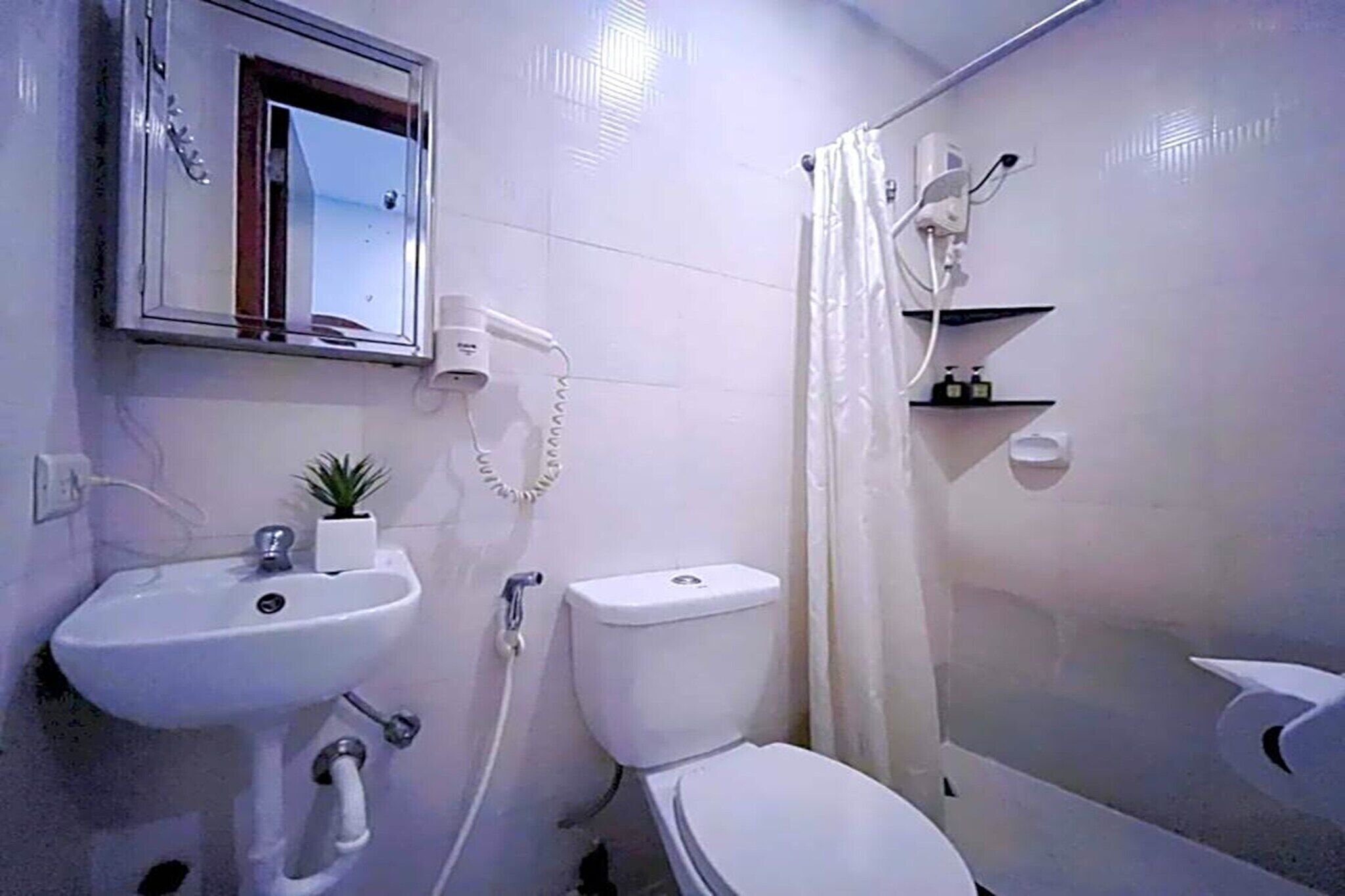 Un baño con lavamanos, inodoro y ducha.