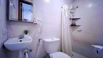 Un baño con lavamanos, inodoro y ducha.