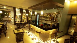 Un restaurant doté d’un bar, de plusieurs tables et de chaises.
