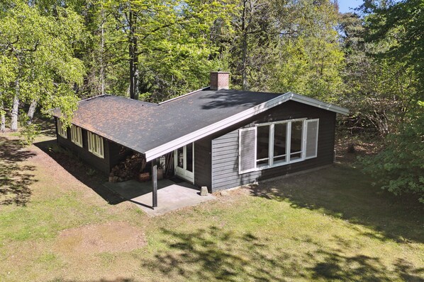 A single-story house with a sloped roof, a chimney, and a covered porch. - Renovated cottage near forest and beach (Rørvig)