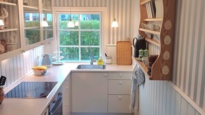 A kitchen with a window, a sink, cabinets, and a countertop. - Lovely cottage close to the water (Karrebæksminde)
