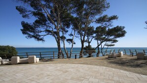 Un espacio al aire libre empedrado con asientos y vistas al mar.