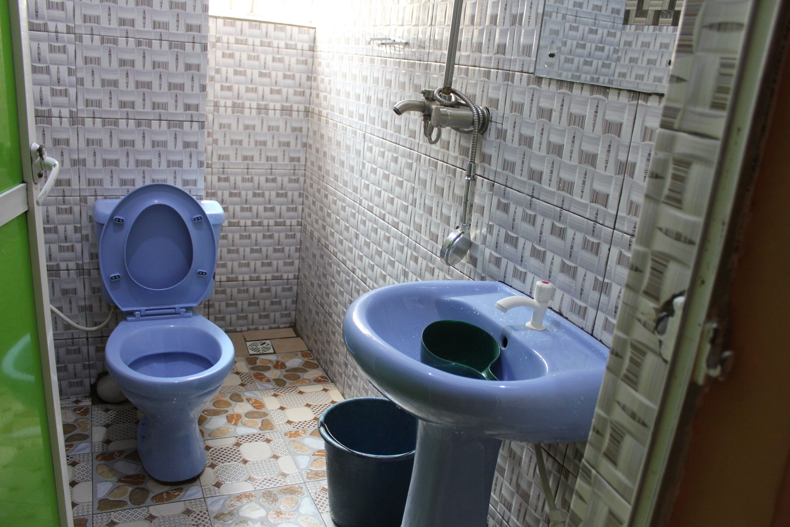 A bathroom with a toilet, sink, and shower.