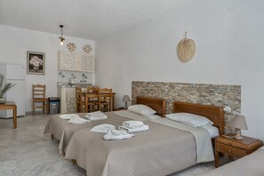 Une chambre d’hôtel avec deux lits, un coin repas, une cuisine et une salle de bain.
