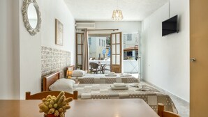 Une chambre d’hôtel avec un lit, une table sur laquelle se trouve un cactus, une télévision et une vue sur l’extérieur.