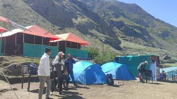 Un grupo de tiendas de campaña en una zona montañosa bajo un cielo despejado.